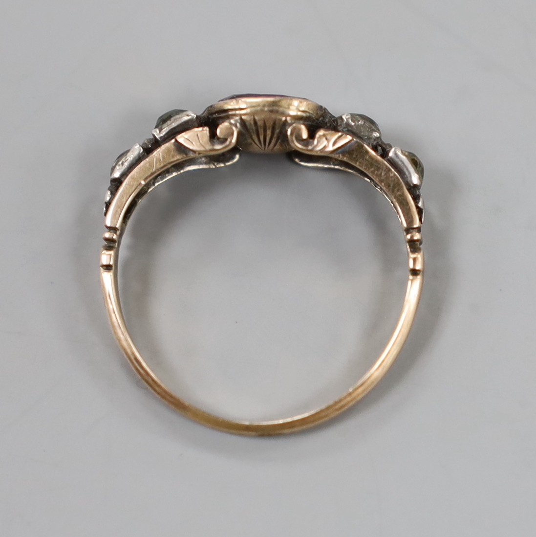 A Georgian yellow metal, garnet and paste set half hoop ring, size P, gross weight 2 grams.
